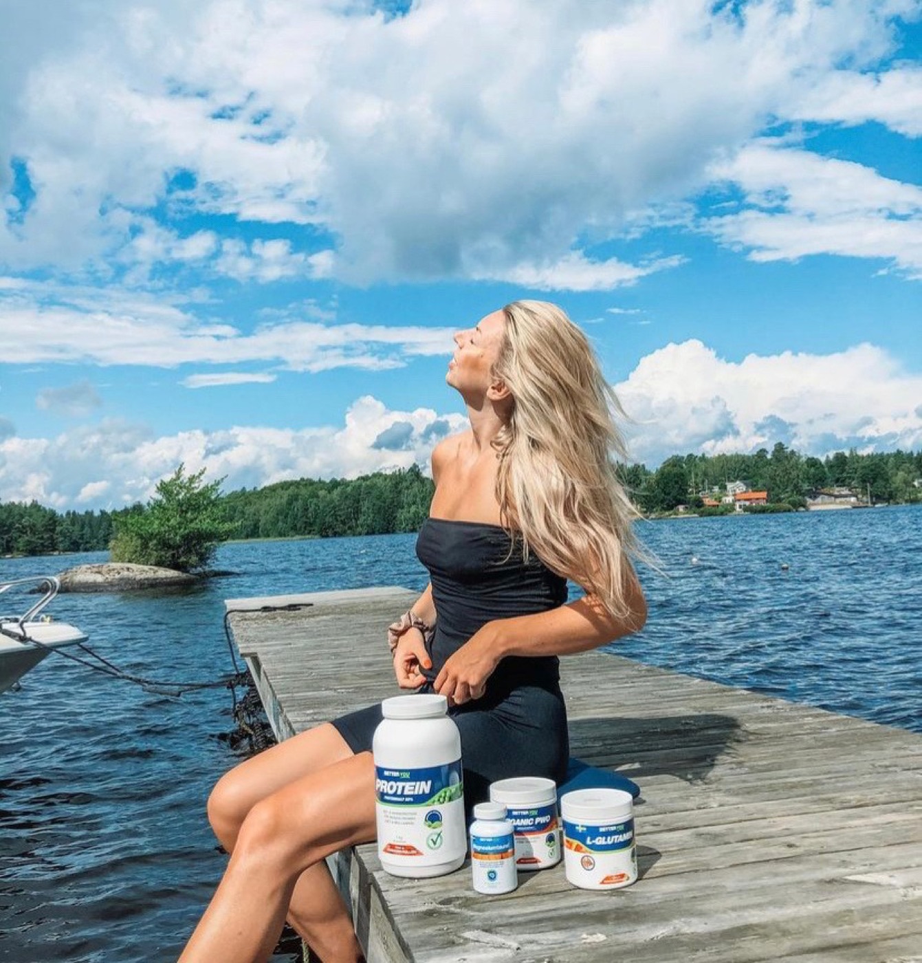 Paulina på en brygga med burkar med kosttillskott